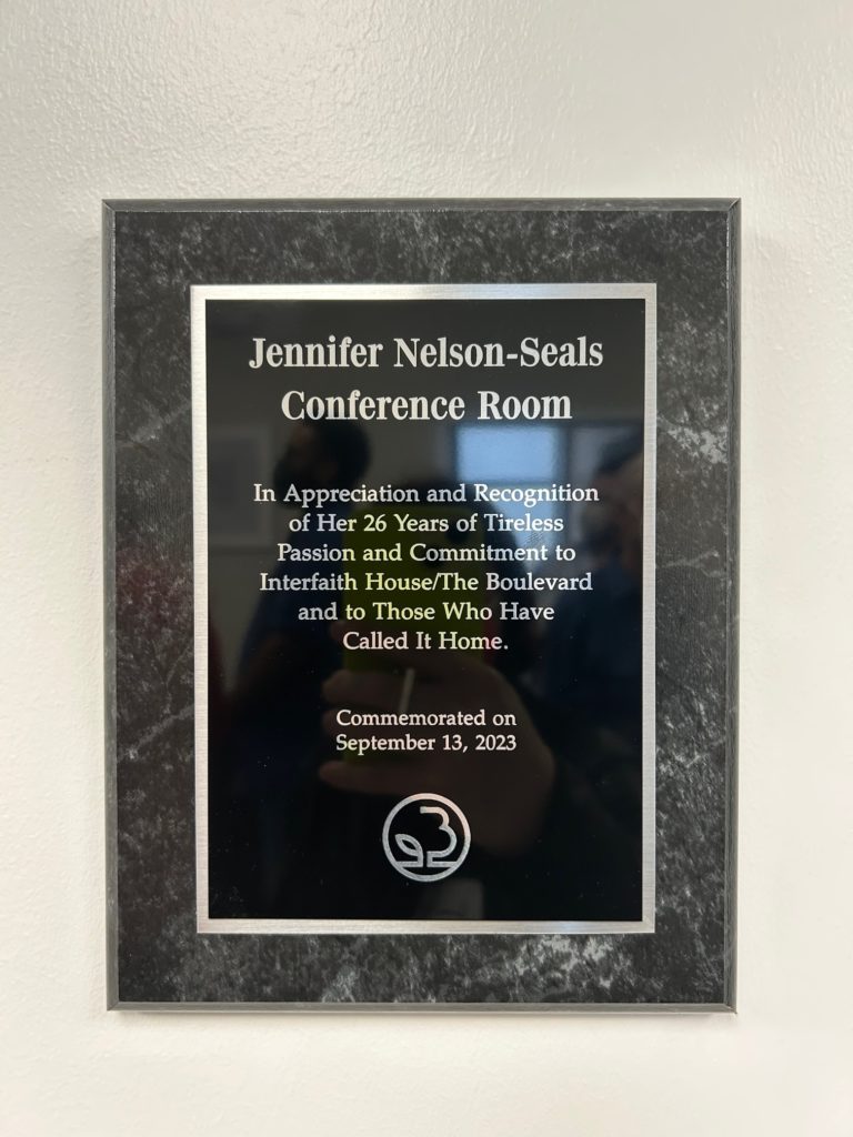 Plaque that says: "Jennifer Nelson-Seals Conference Room. In Appreciation and Recognition of her 26 years of tireless passion and commitment to Interfaith House/The Boulevard and to those who have called it home. Commemorated on September 13, 2023."